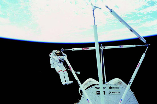Astronaut Jerry Ross works on the EASE structure during STS-61B
in 1985.